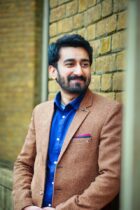 stylish man smiling outdoors in brown blazer