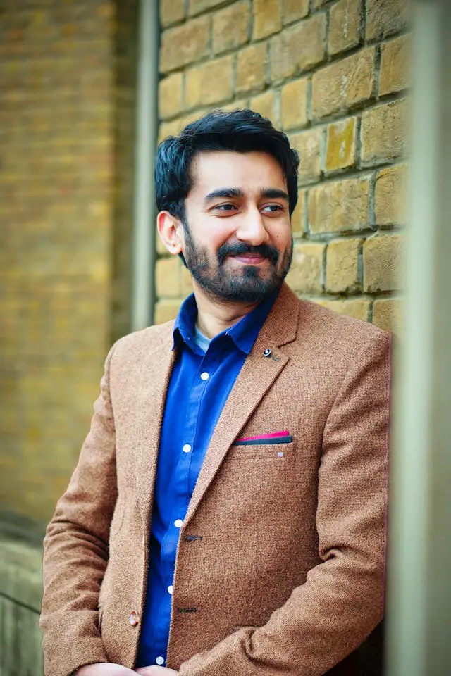 stylish man smiling outdoors in brown blazer