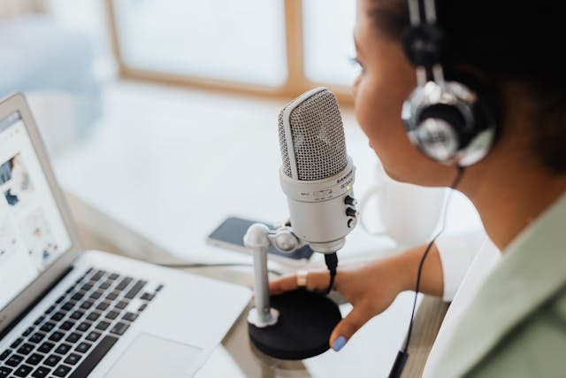woman with headset speaking over a condenser microphone
