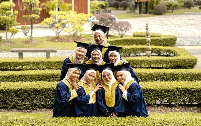 a group of women in graduation gowns posing for a picture