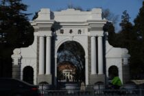 a person riding a bike in front of a white arch
