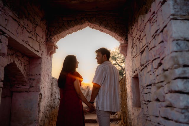 romantic indian couple under archway at sunset