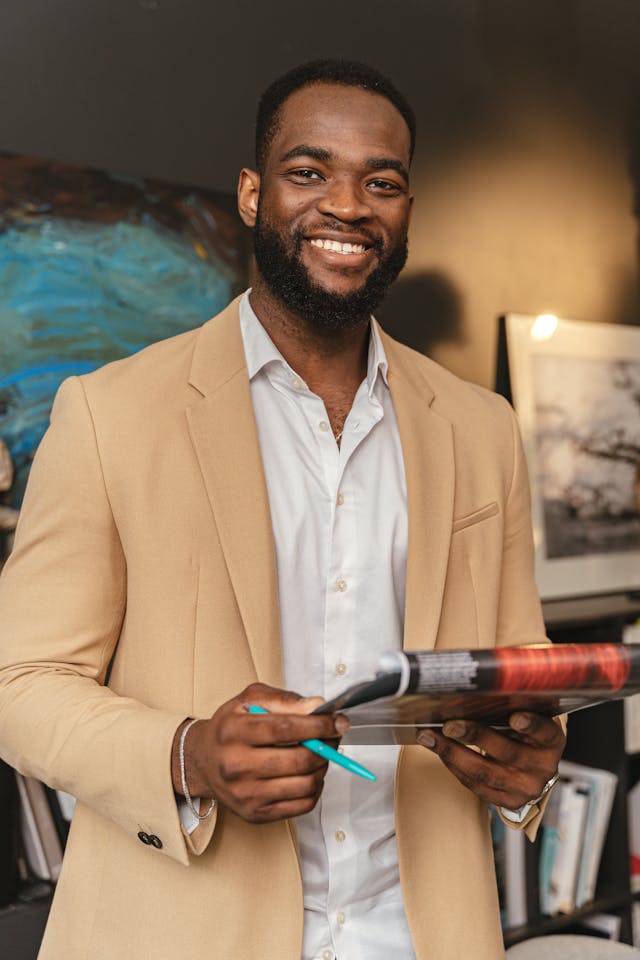 smiling man holding a pen and a clipboard