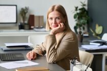 a businesswoman poses at her desk