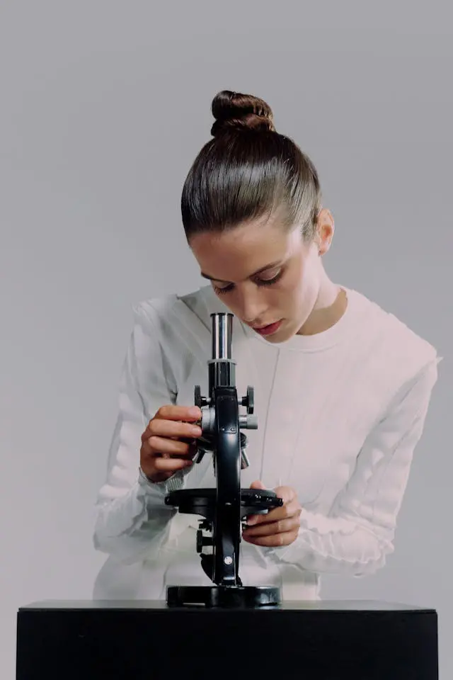 a female scientist looking through microscope