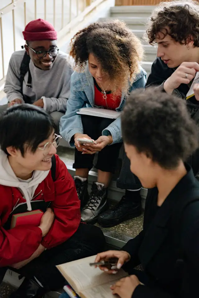 a group of people looking on a smartphone