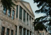 a large building with columns and a clock on the front of it