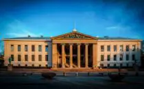 a large building with columns and a flag on top of it
