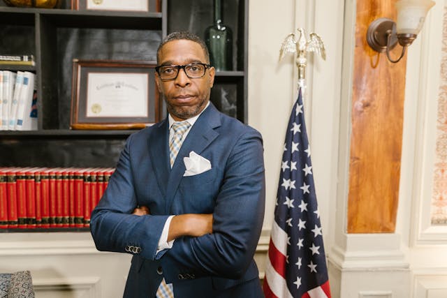 a man in blue suit jacket wearing eyeglasses