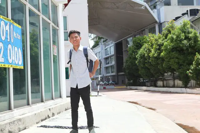a young man standing in front of a building
