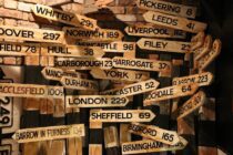 brown wooden signage hanging beside wall