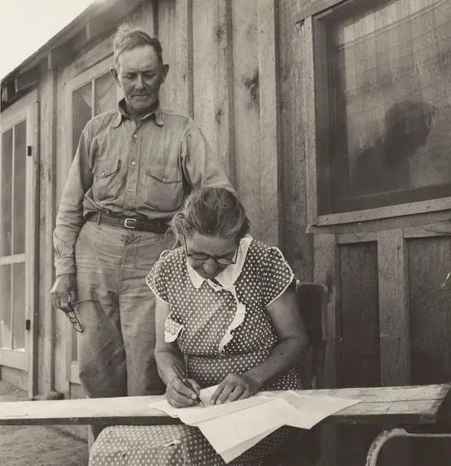 grayscal photo of man standing beside woman