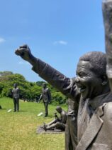 sculptures of famous people on a field outdoors