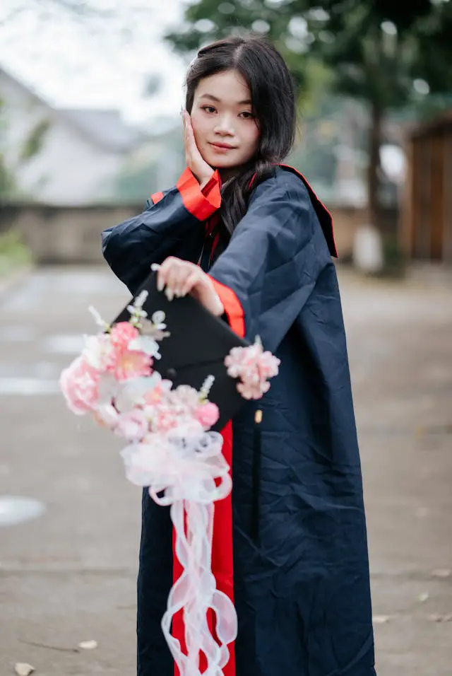 young graduate celebrating outdoors with flowers