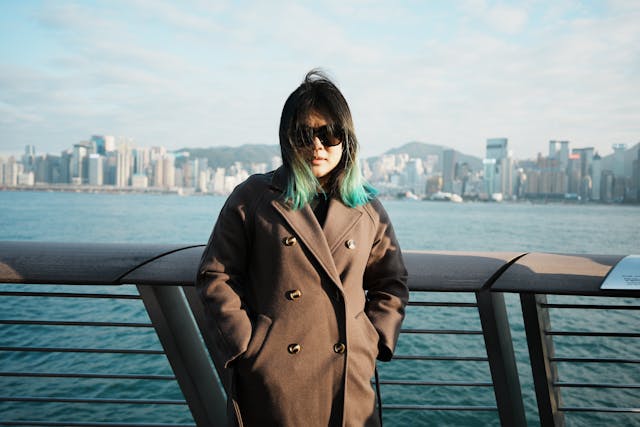 young woman at waterfront with urban skyline