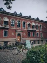 a brick building with many windows and bicycles parked in front of it