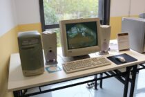 a desk with a monitor keyboard mouse and speakers
