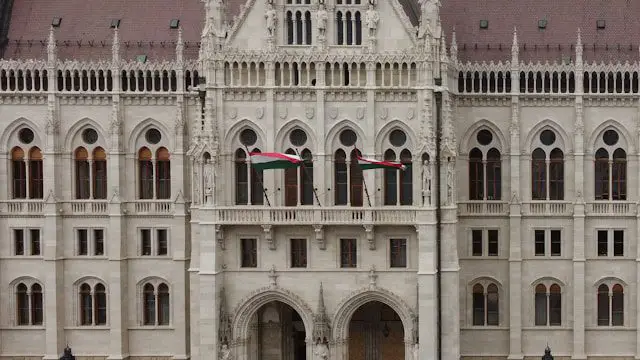 a large white building with two flags on top of it