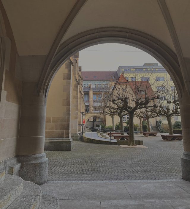 an archway leading to a building with a clock on it