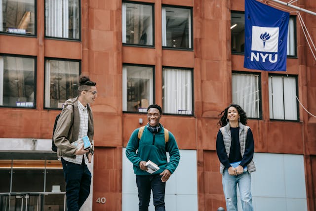 happy diverse students with textbooks smiling near university