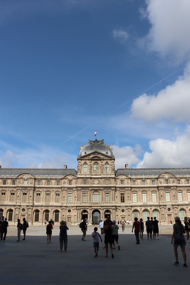 tourists in courtyard of louvre museum paris