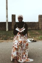 woman in long dress sitting reading a book