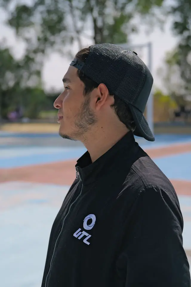 youthful man in cap at outdoor sports court