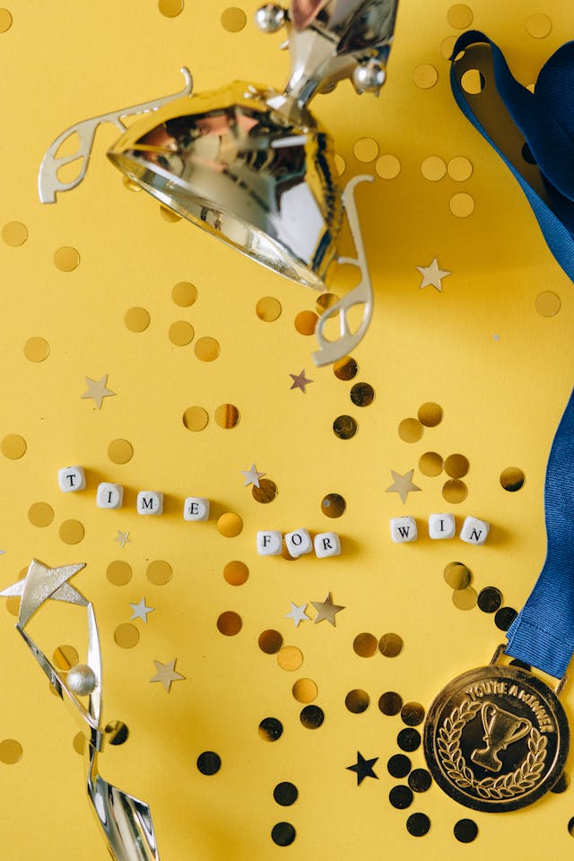 medal on ribbon golden cup statuette and dice with time for win message