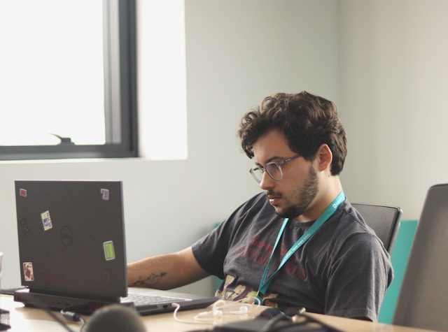a man sitting in front of a laptop computer