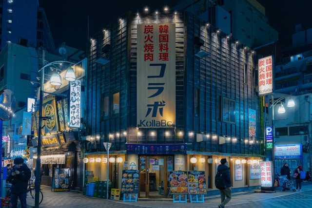 a city street at night with people walking around