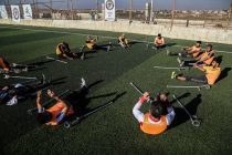 photo of people sitting on green grass field