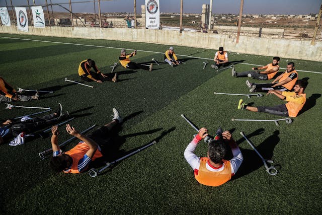photo of people sitting on green grass field