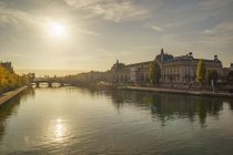 the sun is setting over the river in paris