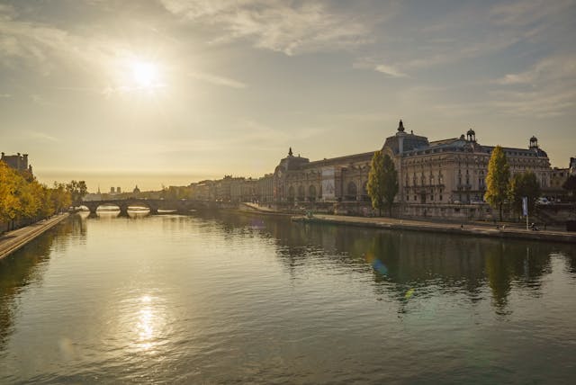 the sun is setting over the river in paris