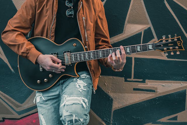 a person playing the electric guitar