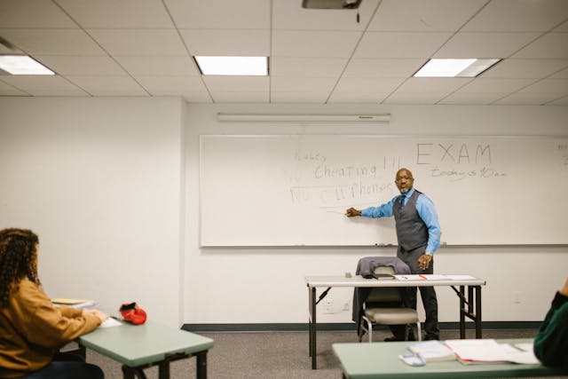 teacher giving instructions to his students not to cheat